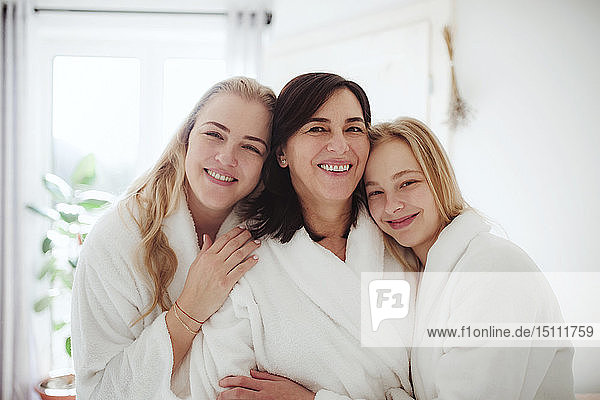 Portrait of happy mature woman with two daughters in a bathroom at home