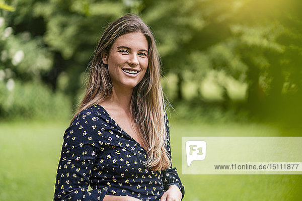 Smiling young woman in park