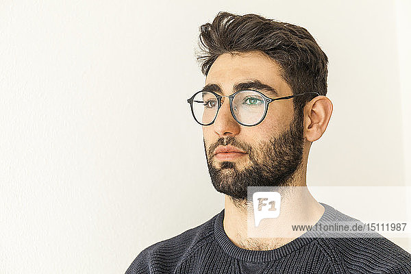 Porträt eines nachdenklichen jungen Mannes mit Bart und Brille