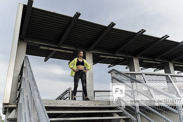 Sporty woman standing on grandstand  looking at distance