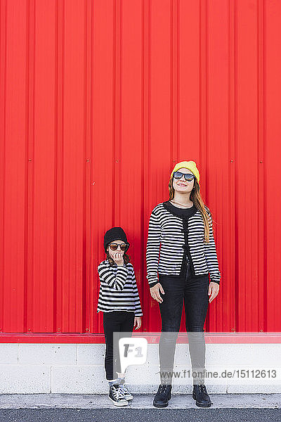 Mädchen im Teenageralter und jüngere Schwester tragen Mützen und Sonnenbrillen