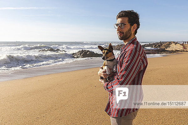 Portugal  Porto  junger Mann am Strand mit seinem Hund