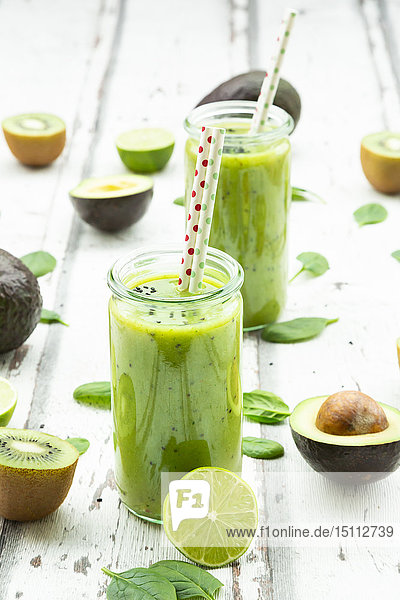 Zwei Gläser grüner Smoothie mit Avocado  Spinat  Kiwi und Limette
