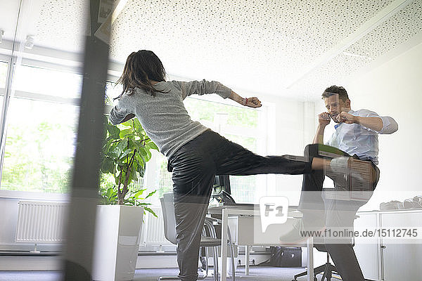 Businessman and businesswoman fighting in office