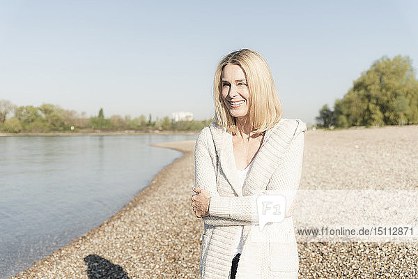 Lächelnde reife Frau am Flussufer