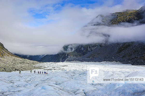 Tourists hiking on Fox Glacier South Island New Zealand