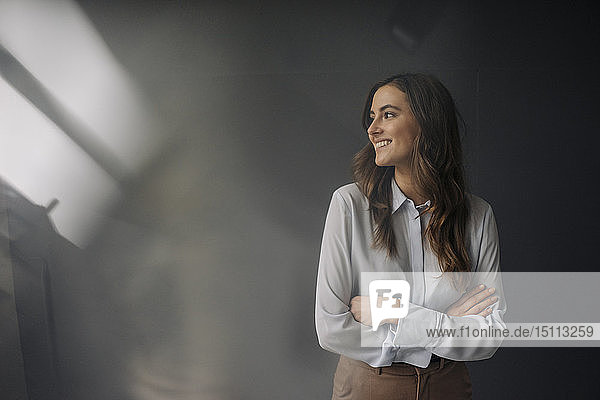 Porträt einer lächelnden jungen Geschäftsfrau  die zur Seite schaut