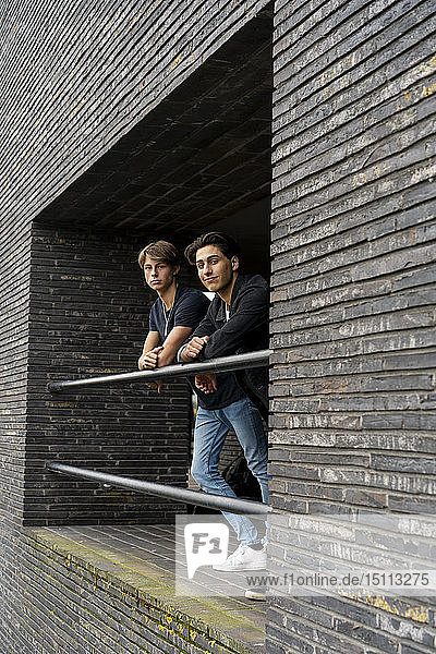 Zwei junge Männer stehen auf einem Balkon eines Gebäudes