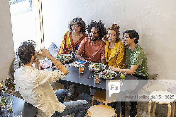 Gruppe von Freunden beim Mittagessen in einem Restaurant beim Fotografieren