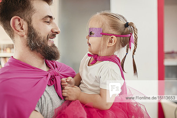 Vater und Tochter spielen Superheld und Superfrau
