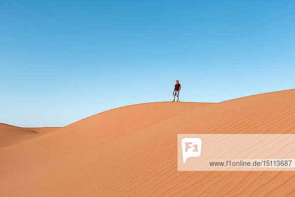 Älterer Mann steht auf einer Düne und schaut auf die Aussicht  Wahiba Sands  Oman