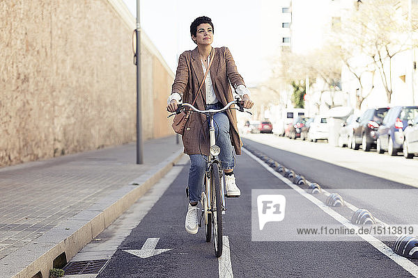Frau mit Fahrrad auf dem Fahrradweg in der Stadt