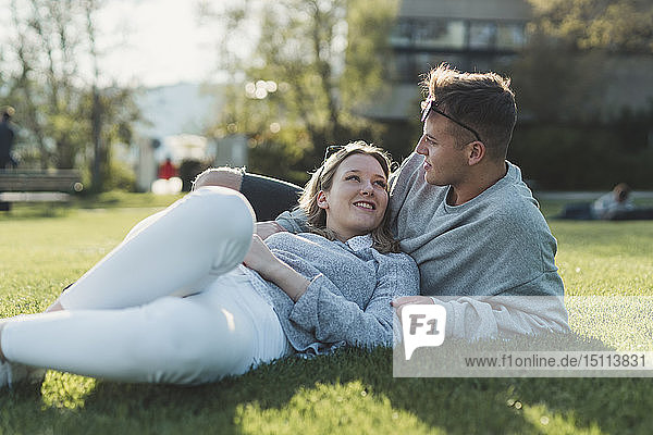Young couple relaxing on a meadow at sunlight