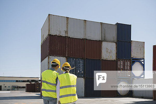 Arbeiter vor Frachtcontainern auf einem Industriegelände