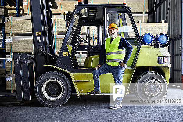 Porträt eines selbstbewussten  reifen Arbeiters am Gabelstapler in der Fabrik