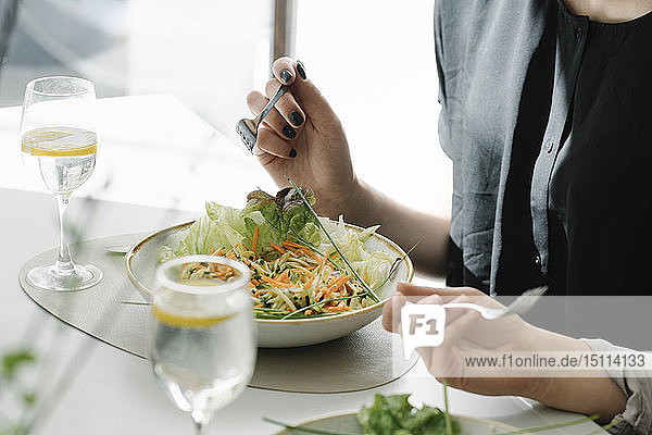Nahaufnahme von zwei Frauen  die in einem Restaurant Salat essen