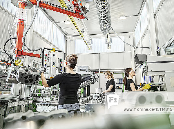 Drei Frauen arbeiten an Maschinen