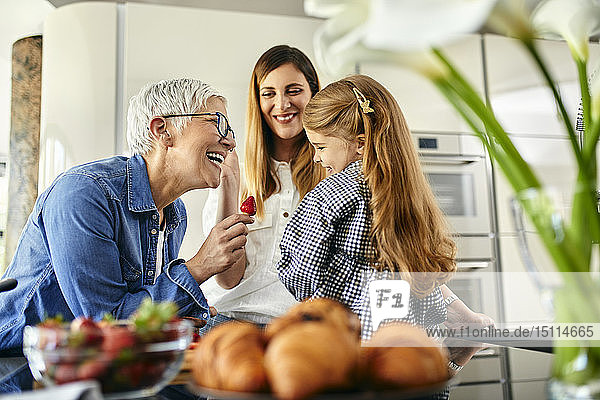 Großmutter bietet Enkelin Stawberry an  Mutter schaut zu