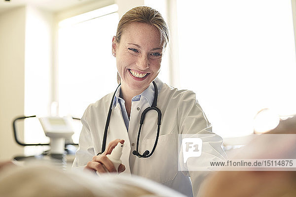 Lächelnde Ärztin bereitet in der medizinischen Praxis eine Blutentnahme bei einem Patienten vor