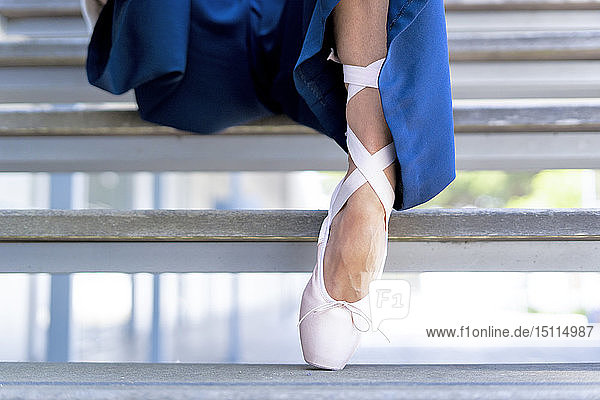 Tänzerin mit Zehenschuh auf Stufen sitzend