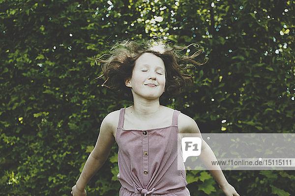 A girl jumping with her eyes closed