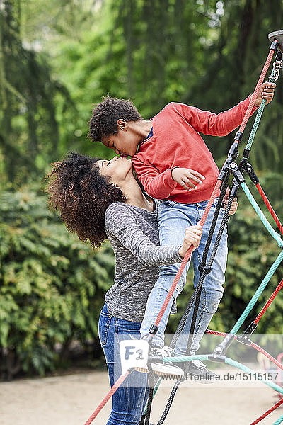 Mutter und Sohn spielen auf einem Spielplatz in einem Park  klettern in einer Kletterhalle im Dschungel