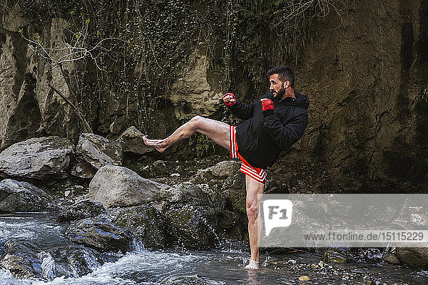 Young man doing boxing workout in nature