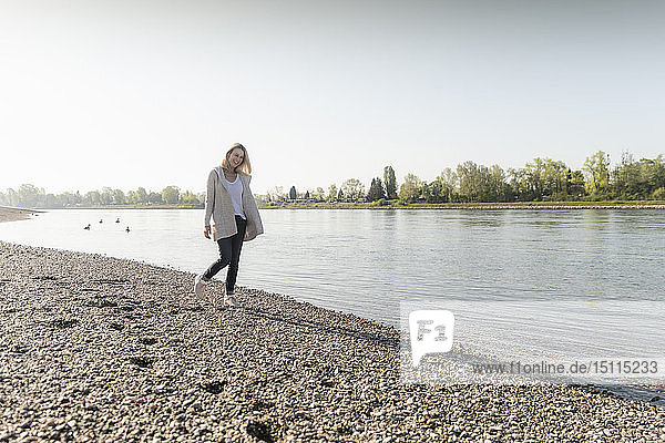 Happy mature woman walking at the riverside