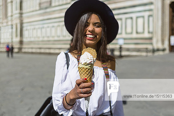 Italien  Florenz  Piazza del Duomo  glücklicher junger Tourist hält Eiswaffel