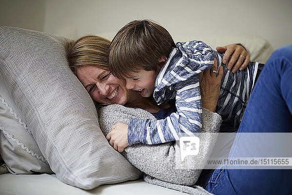 Mutter und Sohn kuscheln auf der Couch