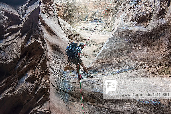 USA  Utah  Moab  Canyonering  Man rapelling down in slot canyon