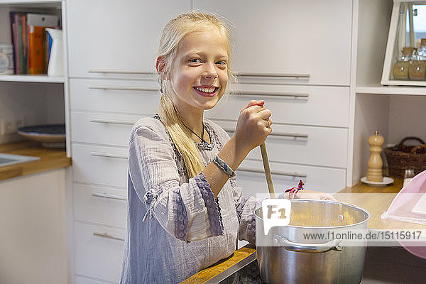 Porträt eines glücklichen Mädchens  das zu Hause Marmelade kocht