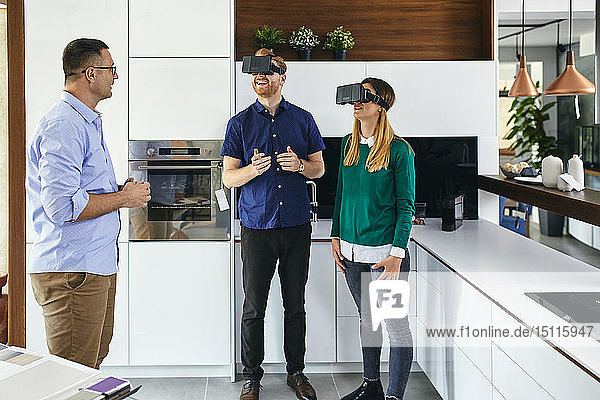 Ehepaar mit VR-Brille beim Einkaufen für eine neue Küche im Ausstellungsraum