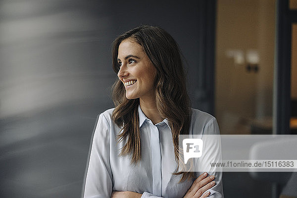 Porträt einer glücklichen jungen Geschäftsfrau  die zur Seite schaut