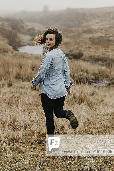 UK  Schottland  Isle of Skye  junge Frau läuft in ländlicher Landschaft