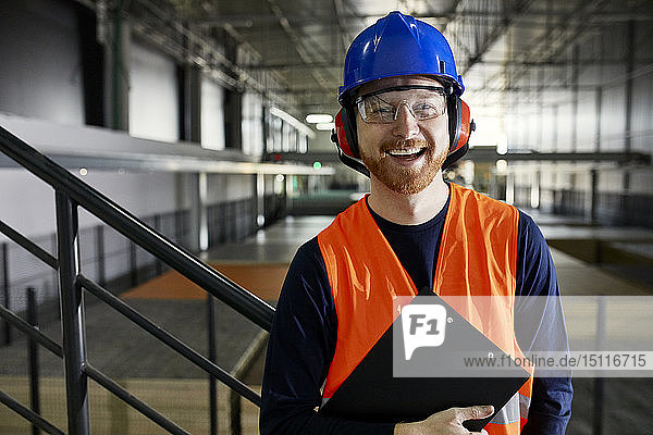 Porträt eines glücklichen Arbeiters im Fabriklager