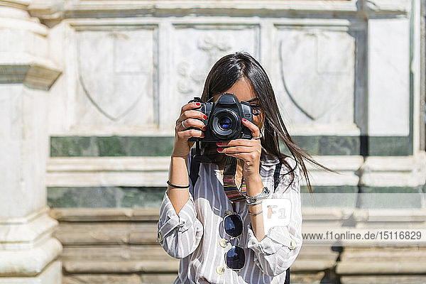 Italien  Florenz  junger Tourist beim Fotografieren mit der Kamera