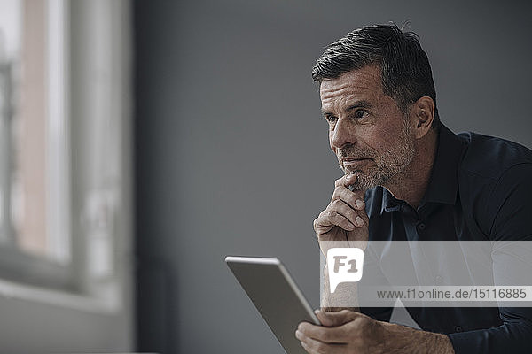Portrait of mature businessman holding tablet
