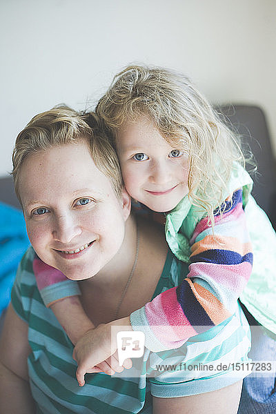 Porträt einer lächelnden Mutter mit Tochter zu Hause