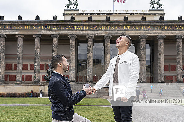 Young man proposing to his surprised boyfriend at Lustgarten  Berlin  Germany