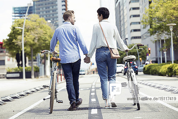 Paar mit Fahrrädern in Barcelona  Rückansicht