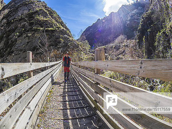 Spain Asturia Cantabrian Mountains senior man on a hiking trip crossing a bridge