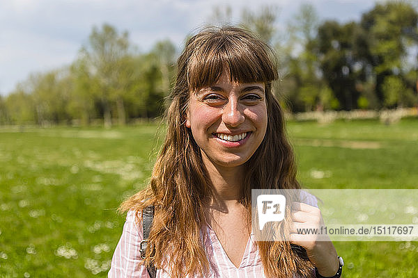 Lächelnde junge Frau in einem Park  Porträt