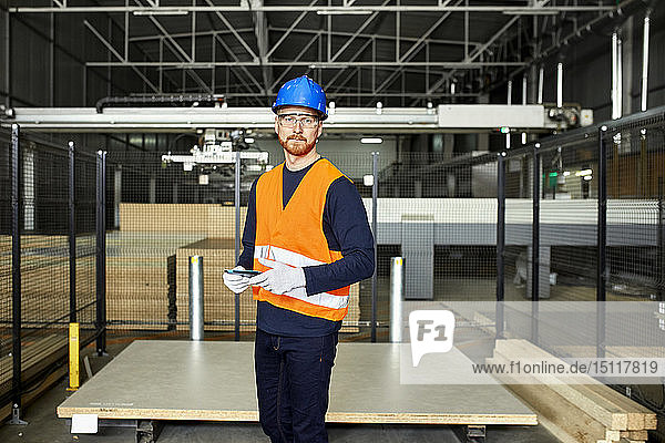Porträt eines Arbeiters mit Tablette im Fabriklager