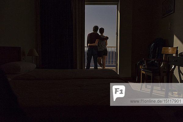 Griechenland  Ehepaar steht nachts auf dem Balkon mit Blick auf das Meer