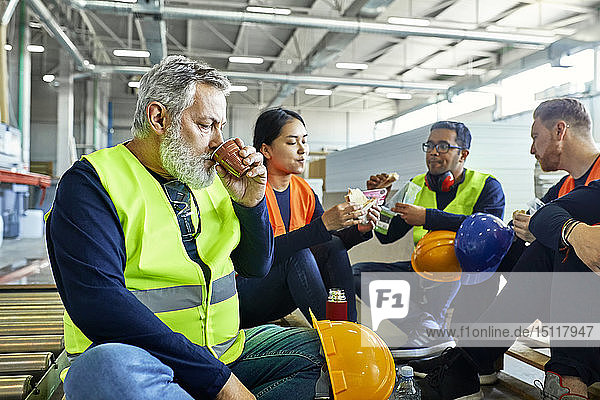Workers in factory having lunch break together