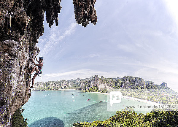Thailand  Krabi  Thaiwand-Wand  Frau klettert in Felswand über dem Meer