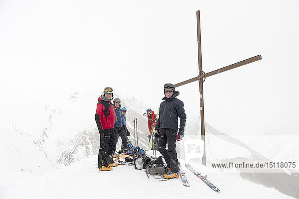 Georgien  Kaukasus  Gudauri  Pinkeln am Gipfelkreuz bei einer Skitour