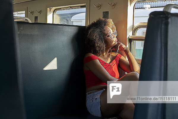 Junge Frau in einem Zug  die aus dem Fenster schaut