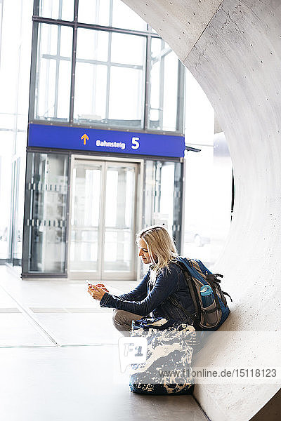 Woman using cell phone at the station